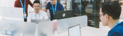 The cloud for continuous delivery image shows a man working on a laptop in the foreground. In the background you see three people working around one computer. A man sits in the middle. On his left is a woman, standing and on his right is a man, standing. All three wear KMS lanyards.