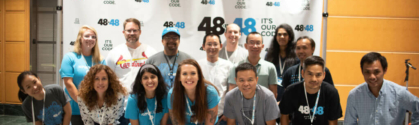 The Atlanta KMS Gives team lines up in front of the 48in48 backdrop before the event.