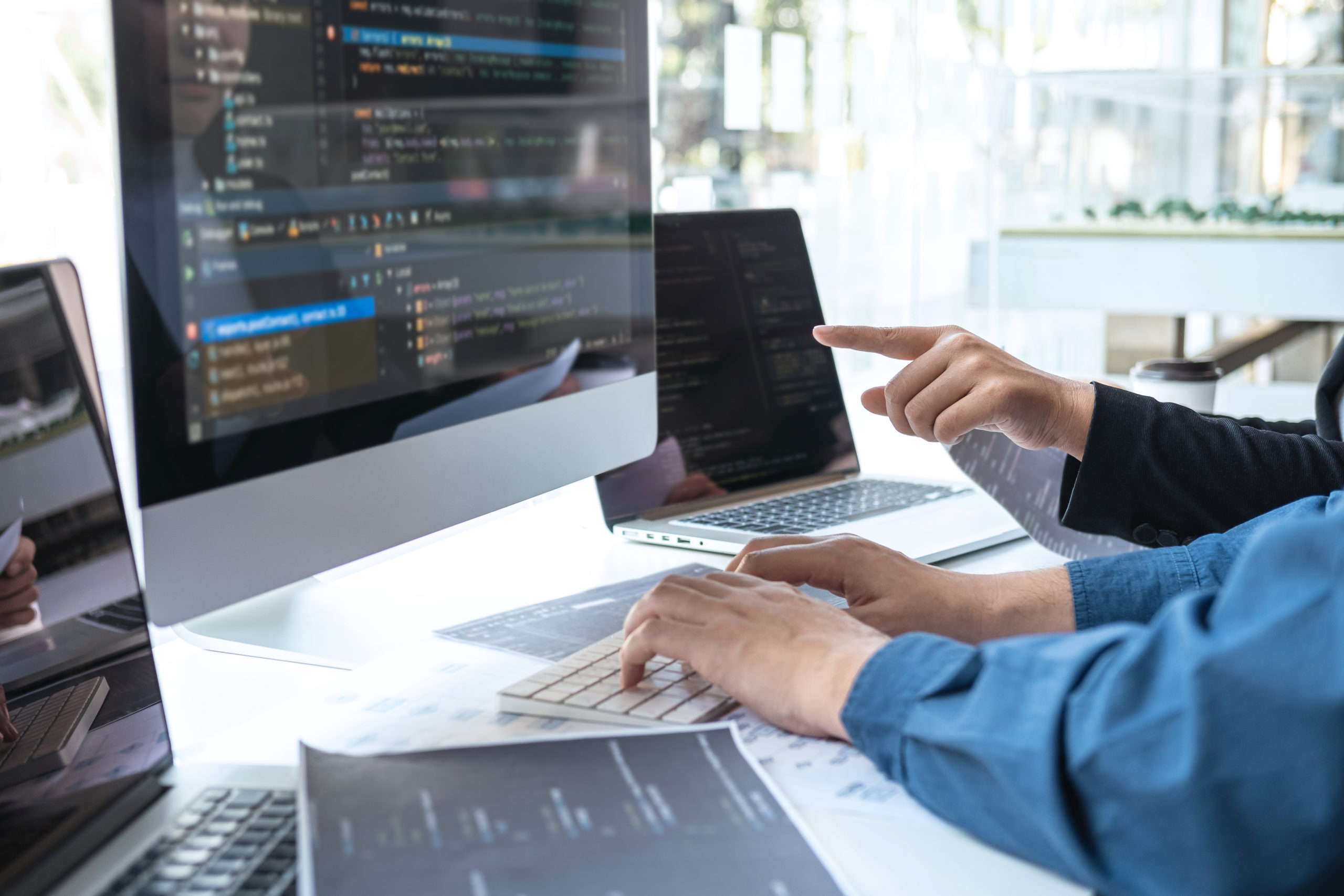 Software developers collaborating on a project at workstation 