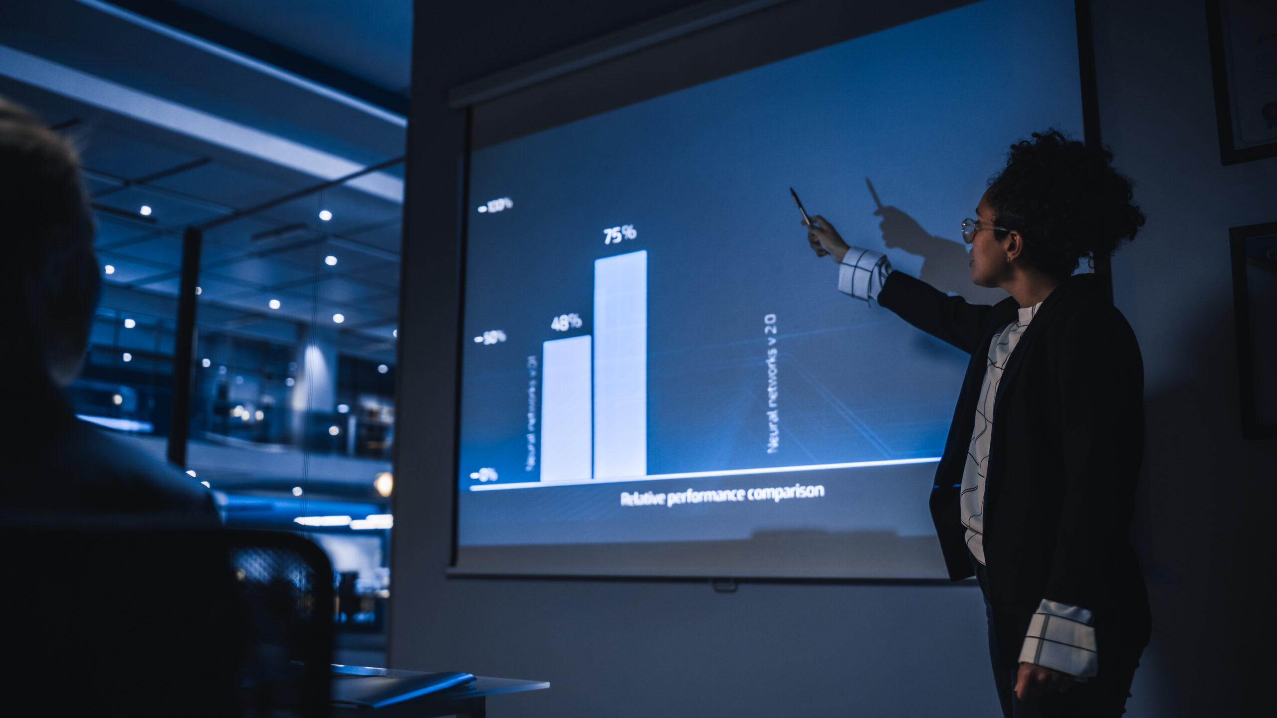 e-Business Technology Conference Presentation: Innovative Black Tech Engineer Talks about Revolutionary High-Tech Product. Projector Screen Shows Graphs, Infographics, AI, Big Data, Machine Learning