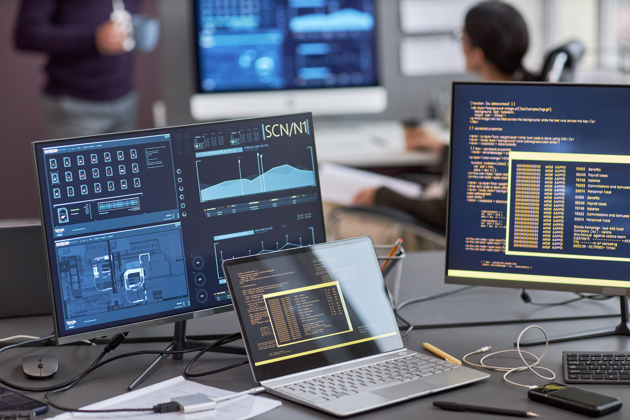 Background image of multiple computer screens with data and code on desk in IT development office, copy space