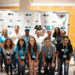 The Atlanta KMS Gives team lines up in front of the 48in48 backdrop before the event.